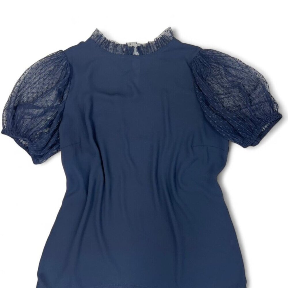 Navy blue puff sleeve blouse with sheer detailing and a high neckline.